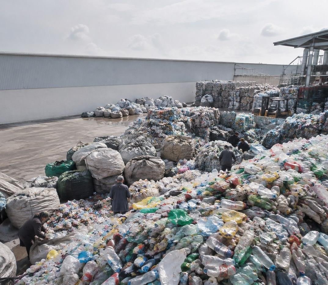 Baled and loose plastic waste stacked at a collection and sorting yard
